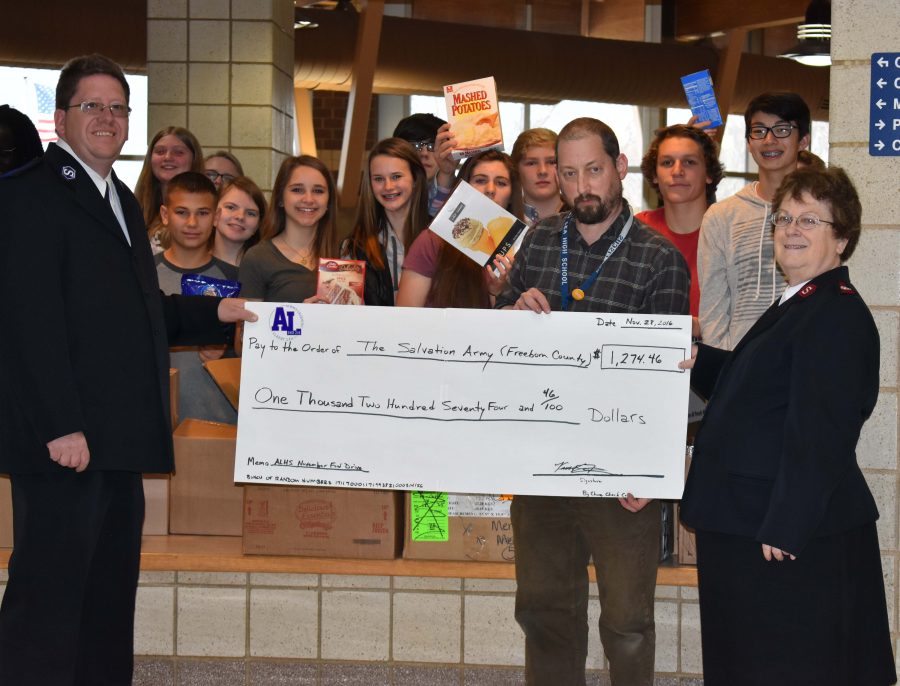 Student Council members smile with the food collected as Fiscus gave a handmade check to the Salvation Army Workers. 