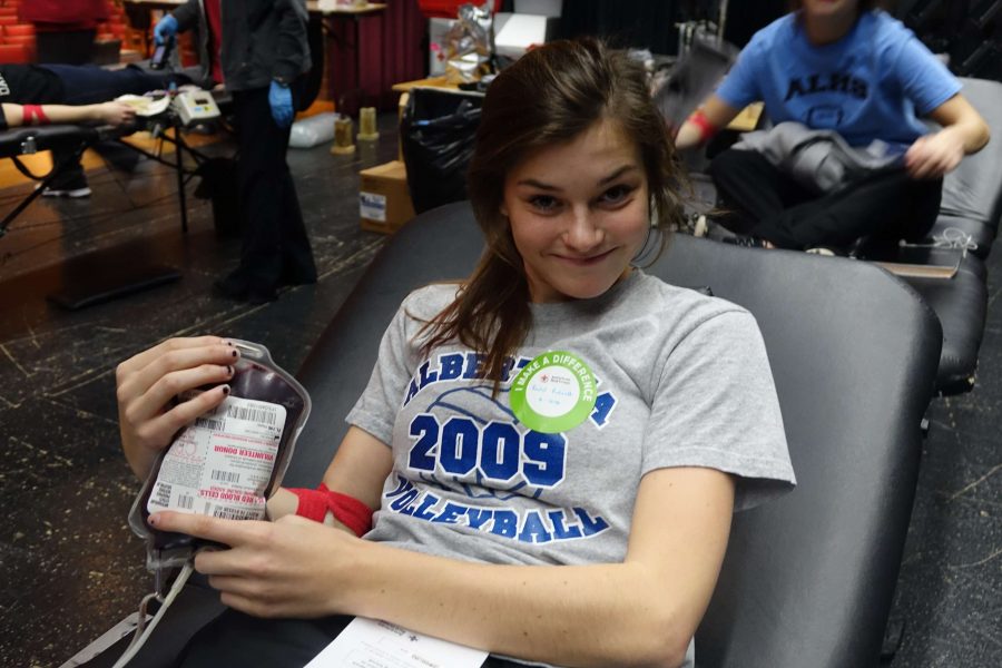 Rachel Rehnelt, junior, poses with the pint of blood she donated.