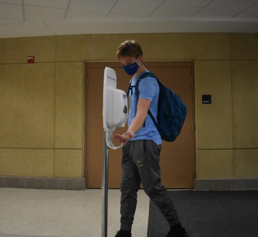 Eighth-grader Bryant Johnston utilizes the hand sanitizer station located in the Commons. Albert Lea High School implemented these stations at every entrance, and there are two thermal scanners situated at the Pool Doors and the Commons entrance as well.