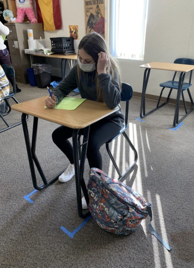 Freshman Emily Heilman sits in class with her backpack. In order to limit the spread of germs amid the COVID-19 pandemic, students have been allowed to carry backpacks instead of utilizing lockers. 
