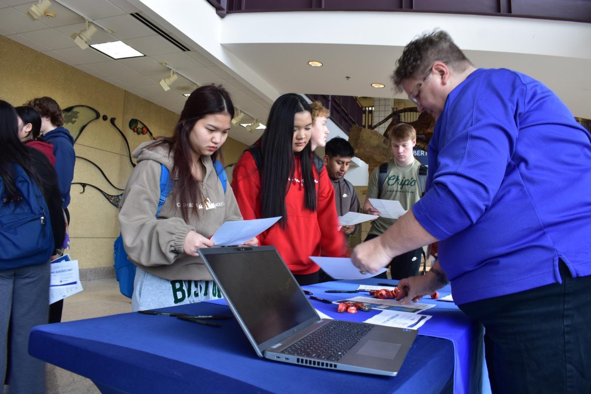 Seniors Paw Ner Moo (left) and Eh Hser Paw (right) talking with Riveland representatives.