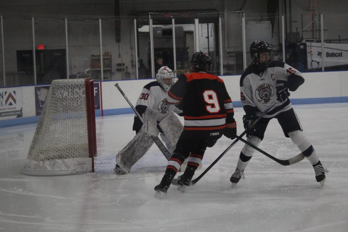 Sienna Murray (11) and Keira Erickson (12) blocking the rival team from scoring a goal in the girls hockey game on November 20th.